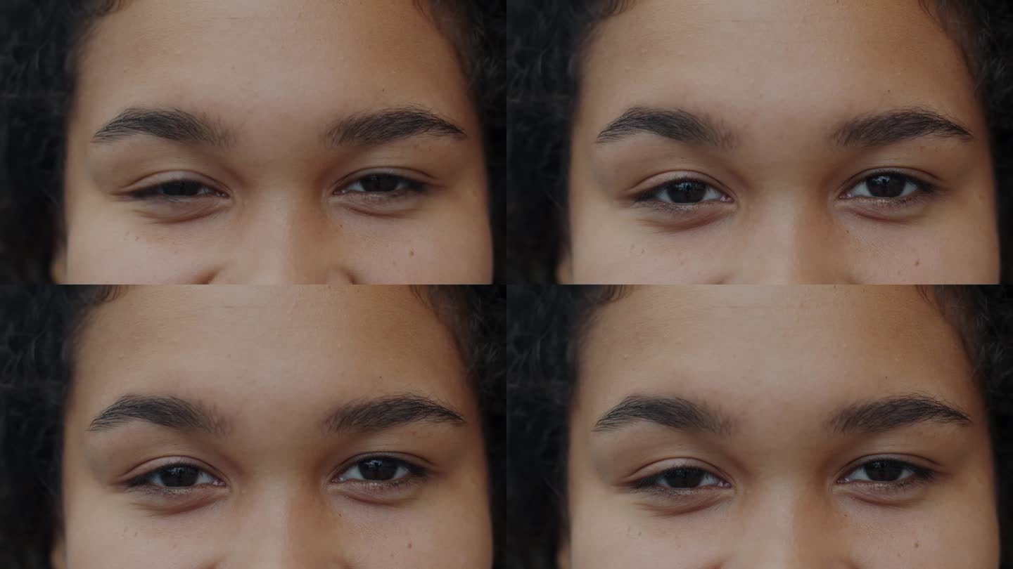 非裔美国妇女的眼睛看着镜头微笑的特写慢动作肖像