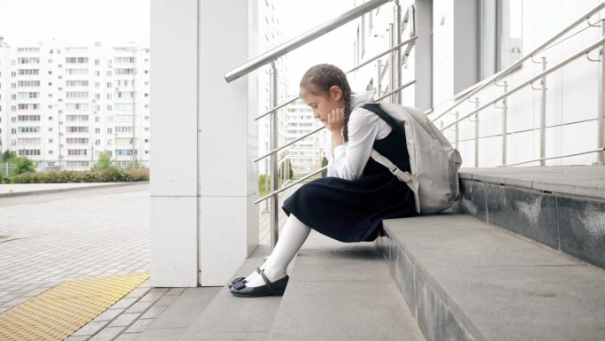 女学生坐在楼梯上，不想上学