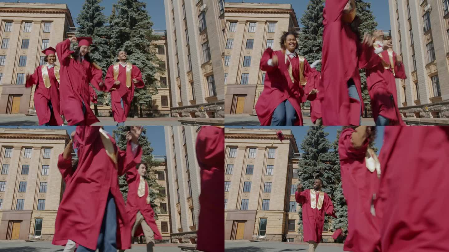 多民族学生在大学校园里奔跑，扔帽子表达毕业那天的快乐