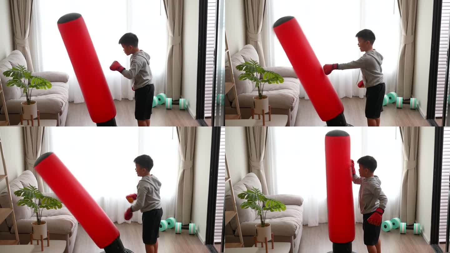 亚洲男孩在家里微笑着练习VR拳击和拳击袋