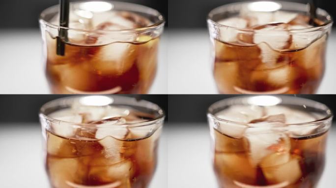 用冰块和湿表面近距离饮用玻璃杯的可口可乐。在微距拍摄下喝汽水或健怡可乐。吃五颜六色的酒吧餐或高糖饮料