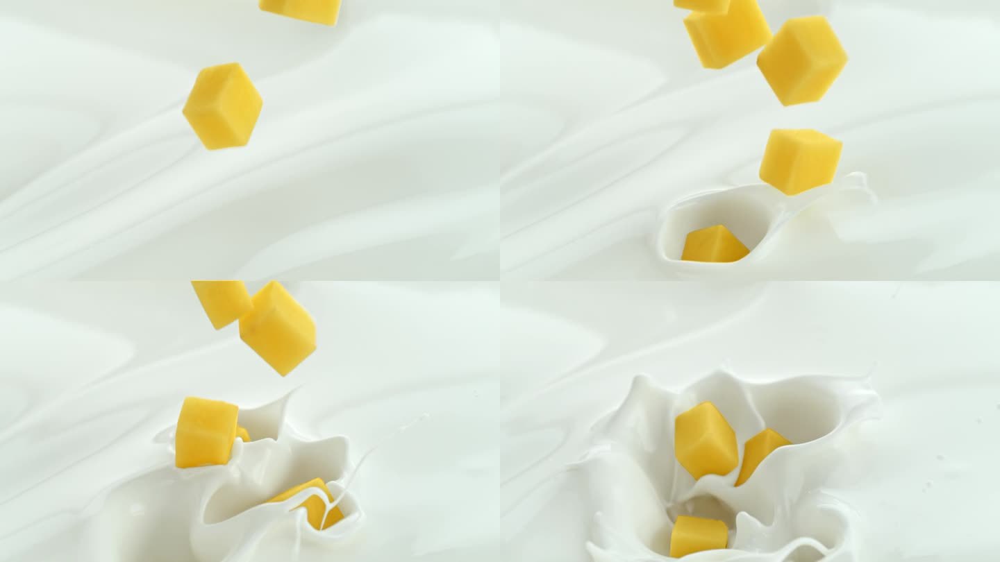 芒果块落入奶油牛奶中，在微距和慢镜头中产生漩涡飞溅