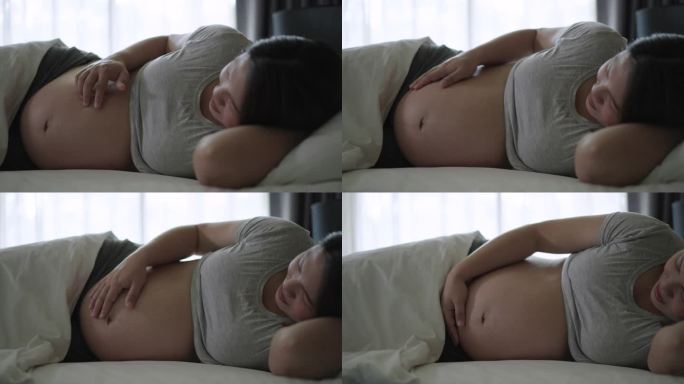 在家里的卧室里，怀着肚子里的宝宝的孕妇有一种爱的感觉和幸福