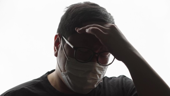 患病的大块头男子戴着口罩咳嗽的正面照片