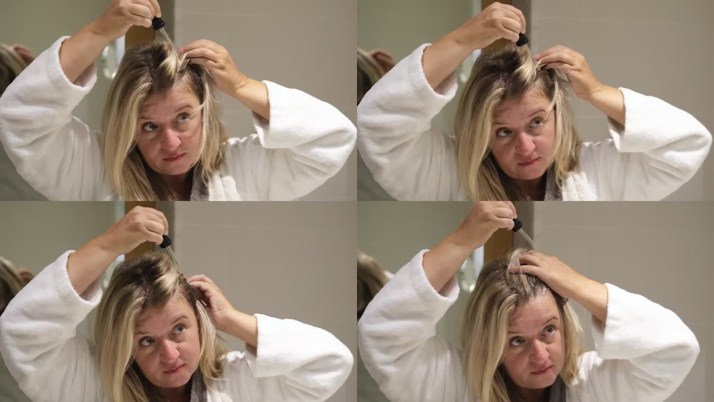 女人用移液管往头发上抹油。美容护理头皮和头发。国内治疗。