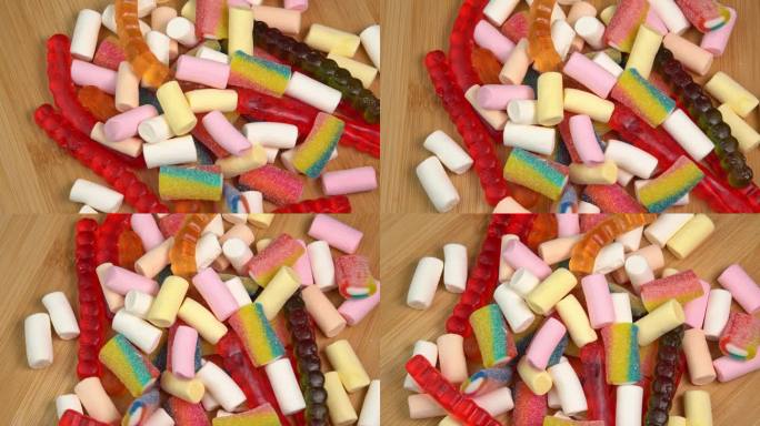 多色软糖果冻在木板上旋转。用糖和明胶或棉花糖制成的彩色软糖果冻糖果