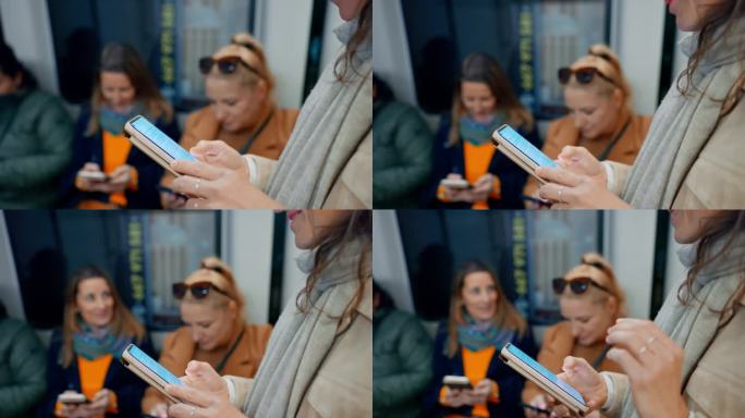 三个女性朋友在地铁车厢里玩智能手机