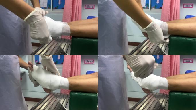 亚洲老年妇女为因糖尿病和压疮受伤而卧床不起的丈夫包扎双腿