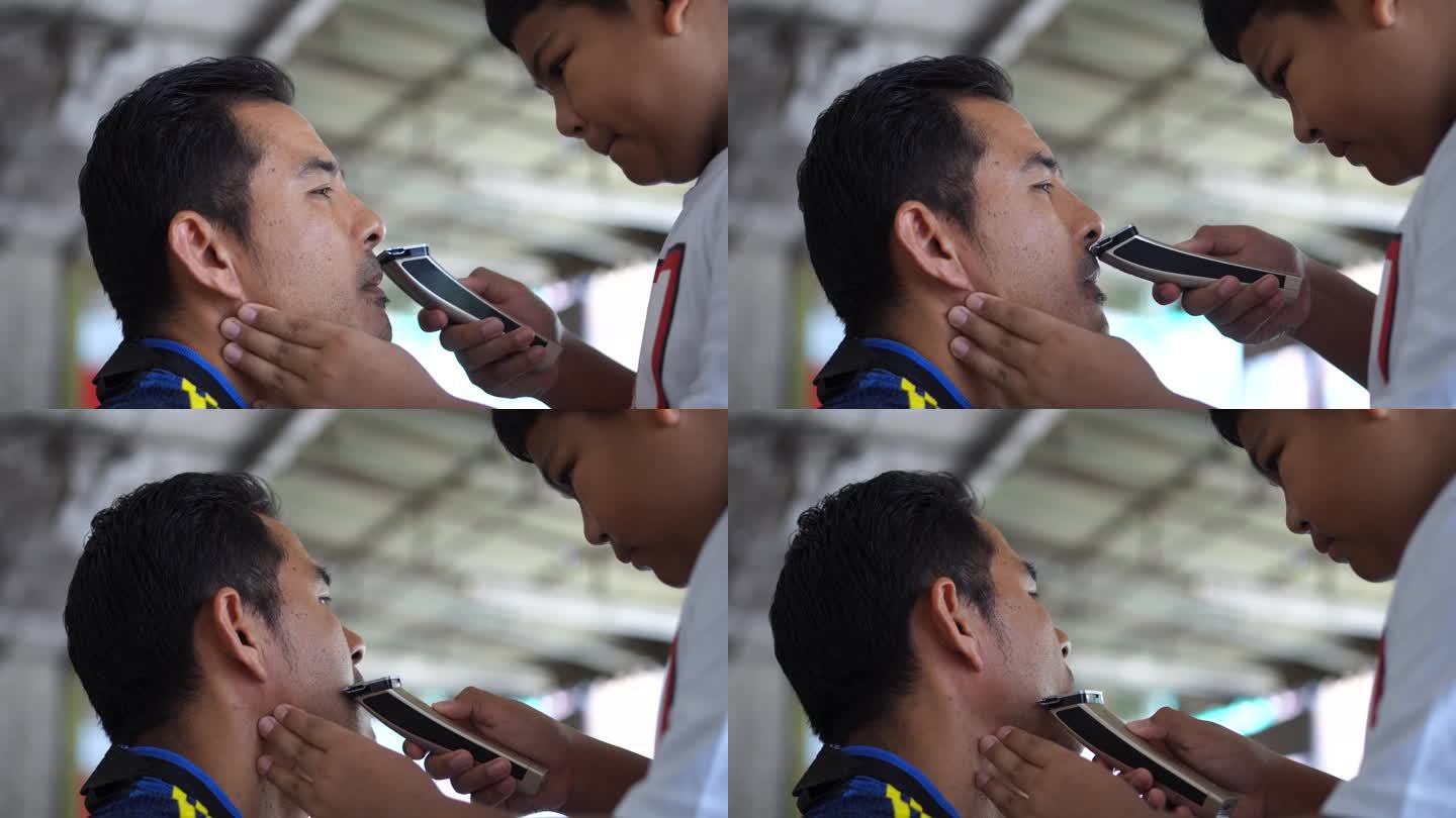 儿子用电动剃须刀给父亲剃胡子