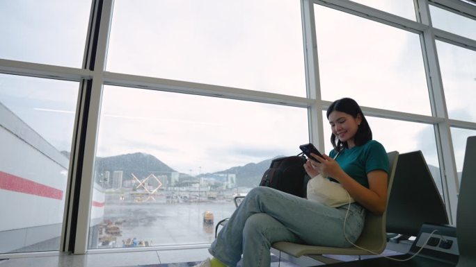 机场提供免费手机充电服务。在候机楼内，一名妇女正等着登上一架客机去旅行。