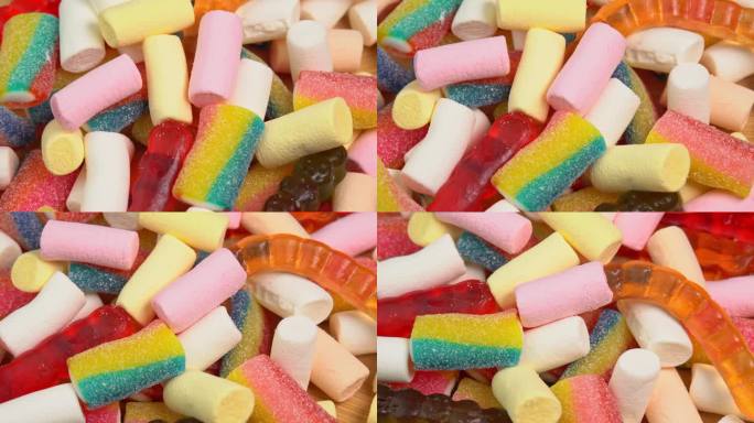多色软糖果冻在木板上旋转。用糖和明胶或棉花糖制成的彩色软糖果冻糖果