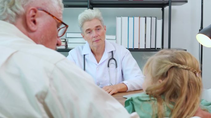 在诊断和向医院专家解释患病女儿时，家人与父亲与医生交谈，医生就女孩的健康，医学概念进行交谈和咨询。