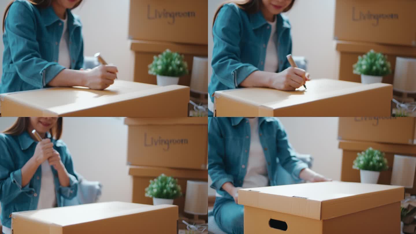 亚洲妇女在打包搬家时在箱子上贴上标签
