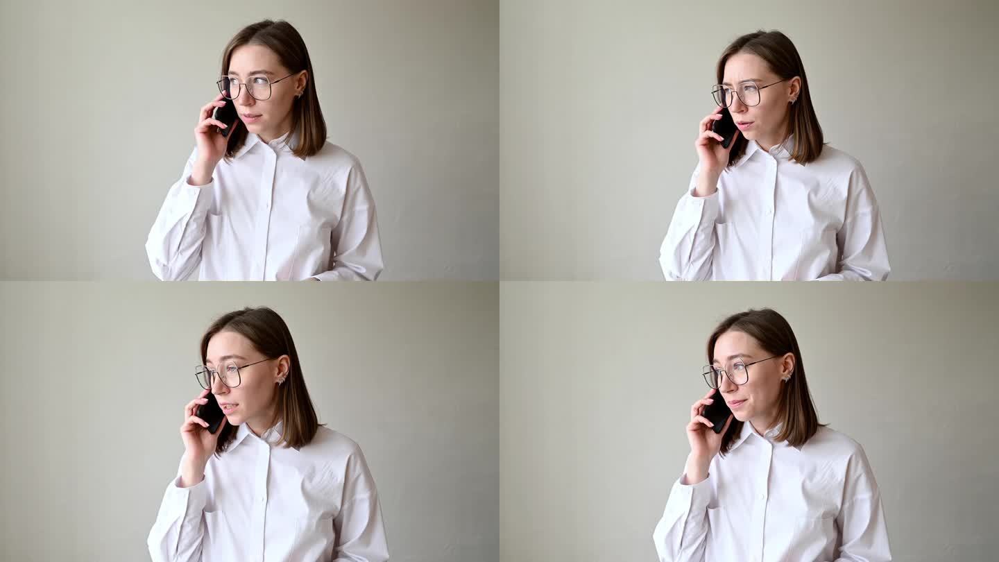 一位穿着白衬衫、戴着眼镜的年轻女子正在打电话，满腹牢骚