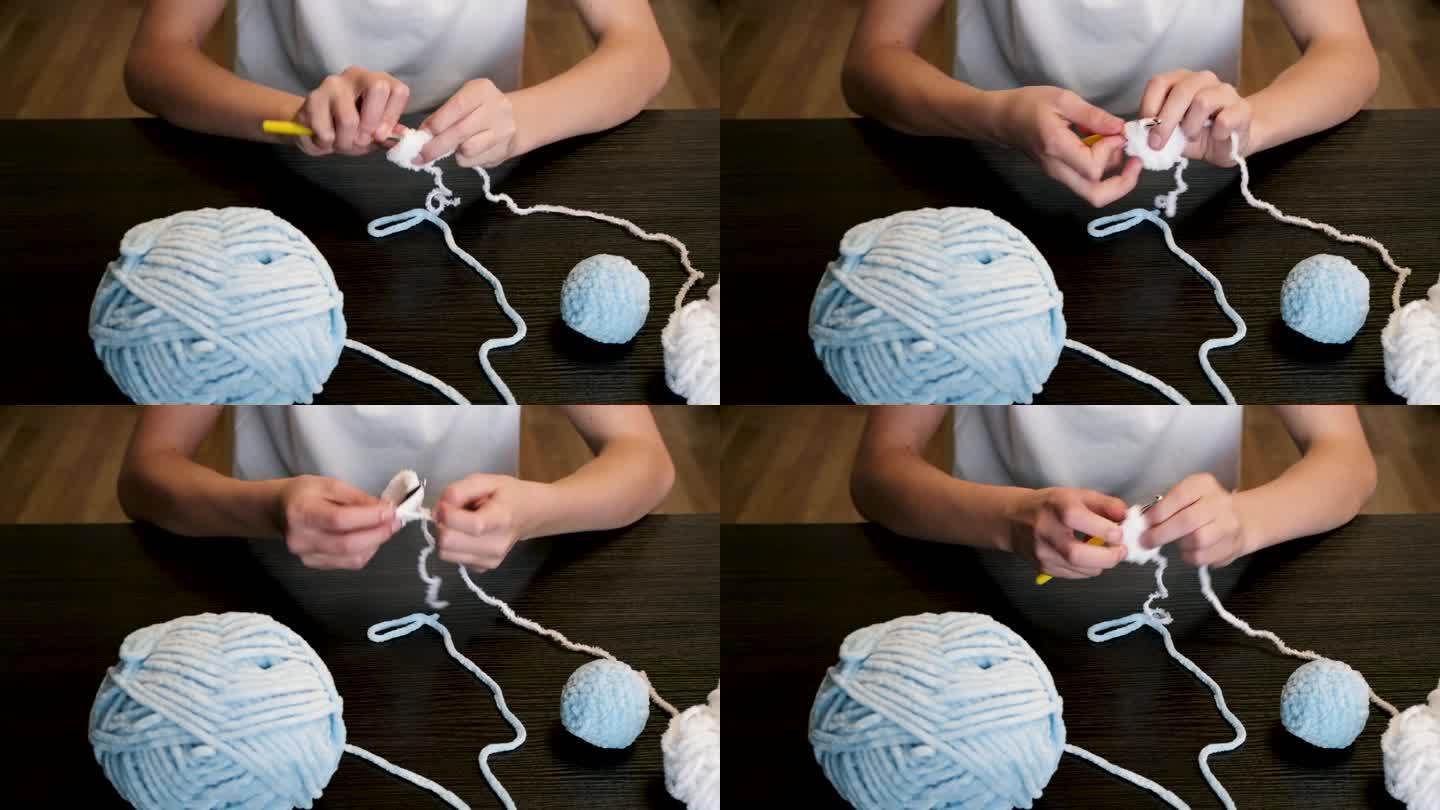 这个女孩一边编织，一边把线拉长。手工制作的。家里的爱好。
