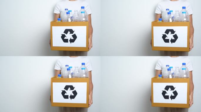 志愿者把塑料瓶放在家里或办公室的纸盒里。手工分类回收垃圾。生态、环保、污染、处置、回收、废物管理和垃
