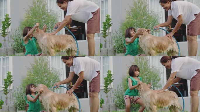 一个亚洲家庭，母亲和女儿在家里的花园里给狗狗洗澡。