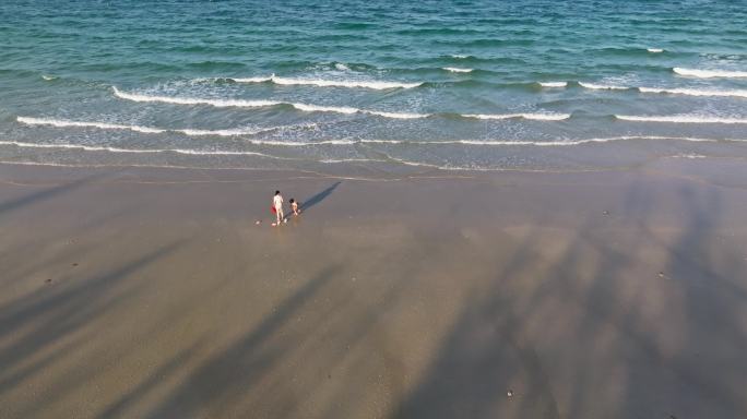 早晨沙滩边玩耍的母女小女孩和妈妈海边散步