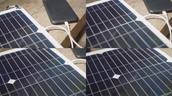 用便携式太阳能电池板给智能手机充电。露营。