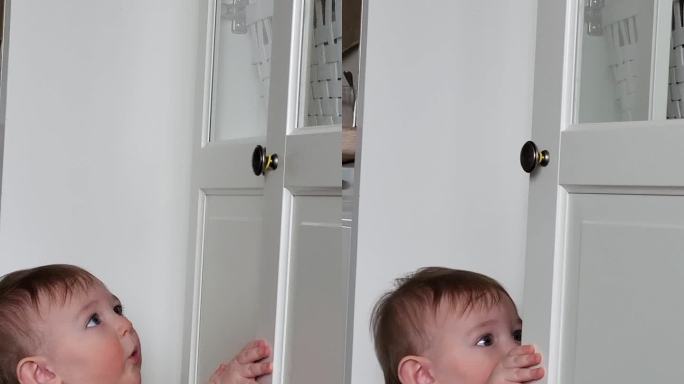 小婴儿打开了一个封闭的壁橱的门。一个好奇的孩子试图打开家具里的抽屉。9个月大的孩子