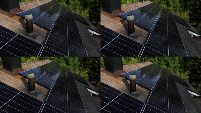 在阳光明媚的夏日，飞过屋顶上的太阳能收集器——鸟瞰图