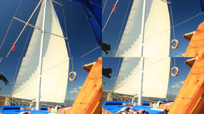 蓝色之旅，土耳其的Gocek邮轮。在深蓝色的天空下，从船帆向下倾斜到游船的上层甲板