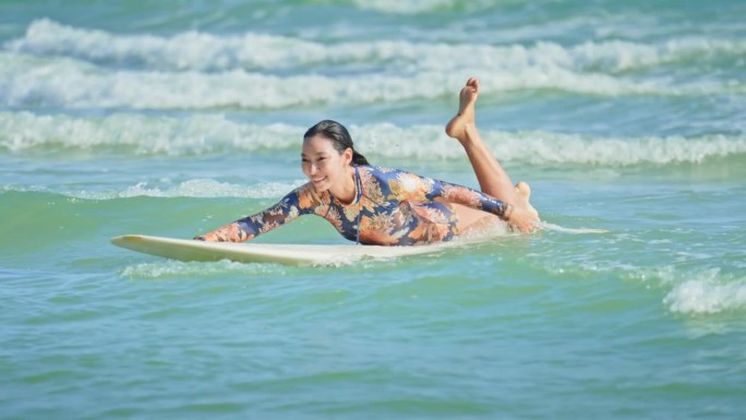 亚洲女人在海上冲浪，慢镜头