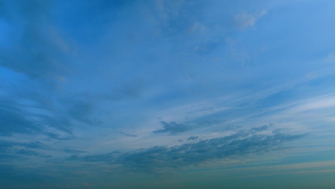 高云，暮时。不同色调的云越过渐暗的蓝色地平线。间隔拍摄。