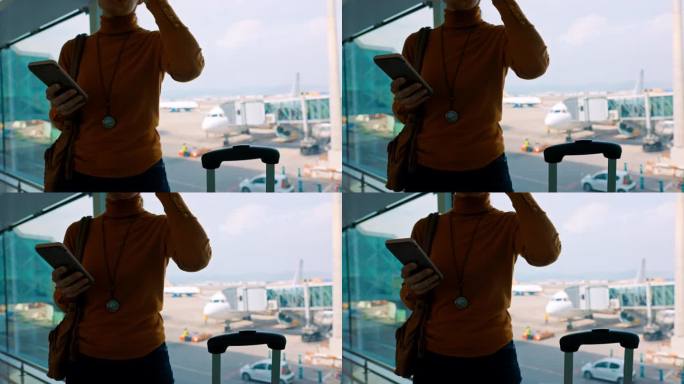 一名拿着智能手机的陌生女子在机场门口等候