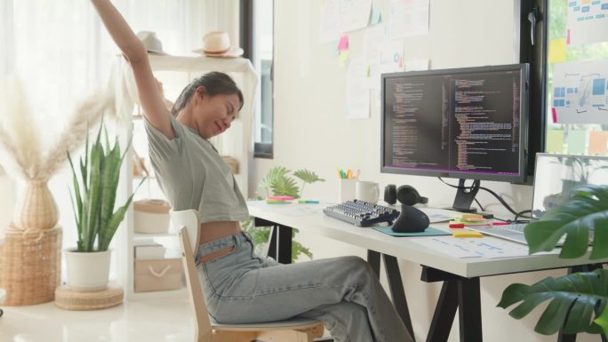 年轻的女孩发展程序员过度工作放松伸展肌肉从办公室综合症疼痛解决问题编码程序在电脑上修复数据库在家庭办
