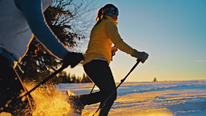 两个女人和一只狗跑过雪坡穿过森林