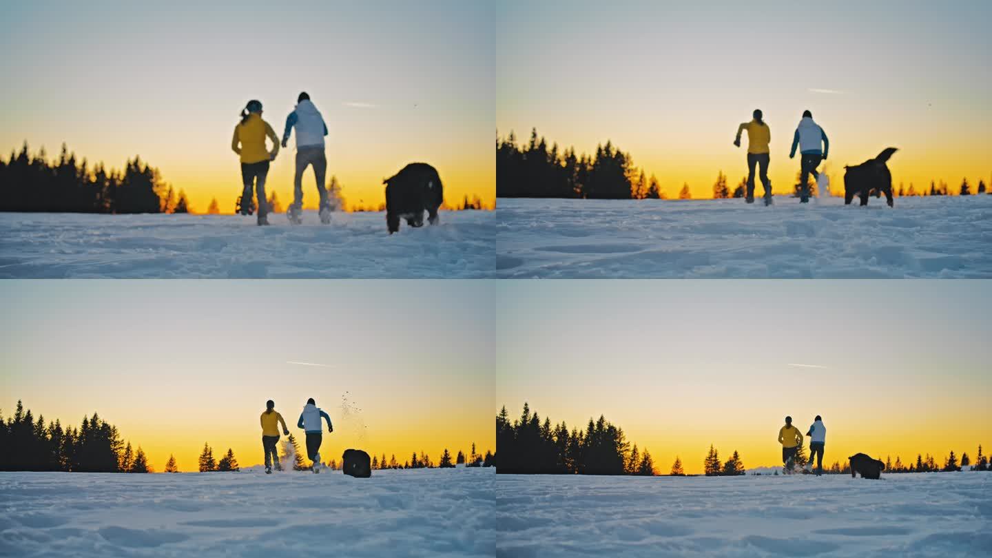 日落时分，两个女人和一只狗在雪坡上奔跑