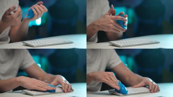 近距离的双手无法识别的清洁清除灰尘从肮脏的白色无线PC键盘使用蓝色粘稠的吸收凝胶。一般清理的概念