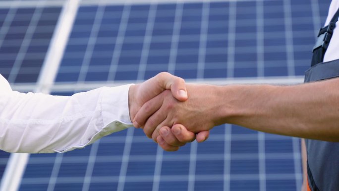 两位工程师在讨论完光伏太阳能板的背景后，老板和下属正在握手