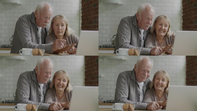 一对老年夫妇在家里的厨房里看着笔记本电脑屏幕讨论内容