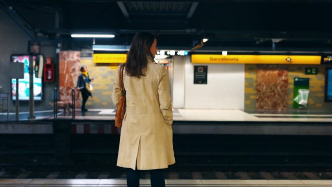 一名女子在地铁站台上等火车