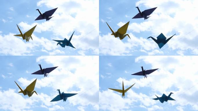 窗户上挂着五颜六色的折纸鸟鹤，映衬着天空。纸鸟似乎会飞。日本风格的折纸鹤是幸福和繁荣的象征。