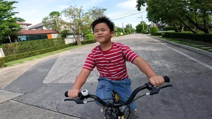 亚洲孩子在小区和跑道上练习骑自行车和踏板车。爱好和休闲的概念