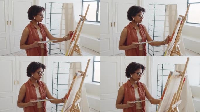 非裔美国妇女在现代公寓的画布上绘画