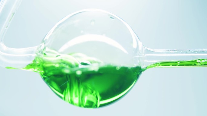 绿色液体在玻璃烧瓶中沸腾。