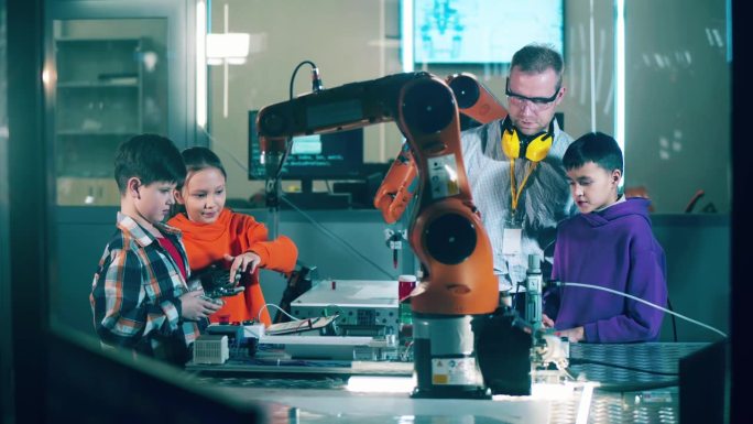 在现代化的实验室里，孩子们在老师的指导下研究机器人