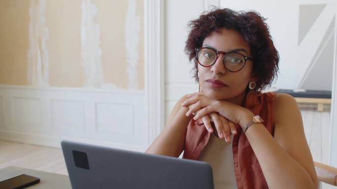 心烦意乱的黑人女性坐在家里拿着笔记本电脑