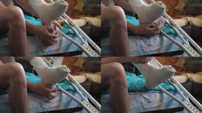一名男子用橡皮筋包扎着酸痛的腿，坐着啜泣，拐杖的概念是骨折和受伤，康复