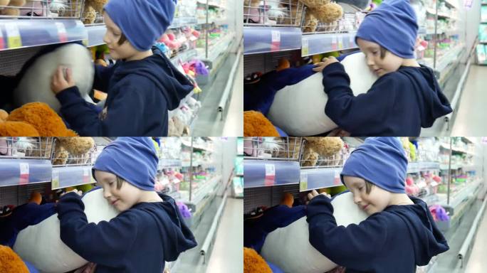 一个可爱的孩子在玩具店拿起一只玩具鲸鱼，拥抱它
