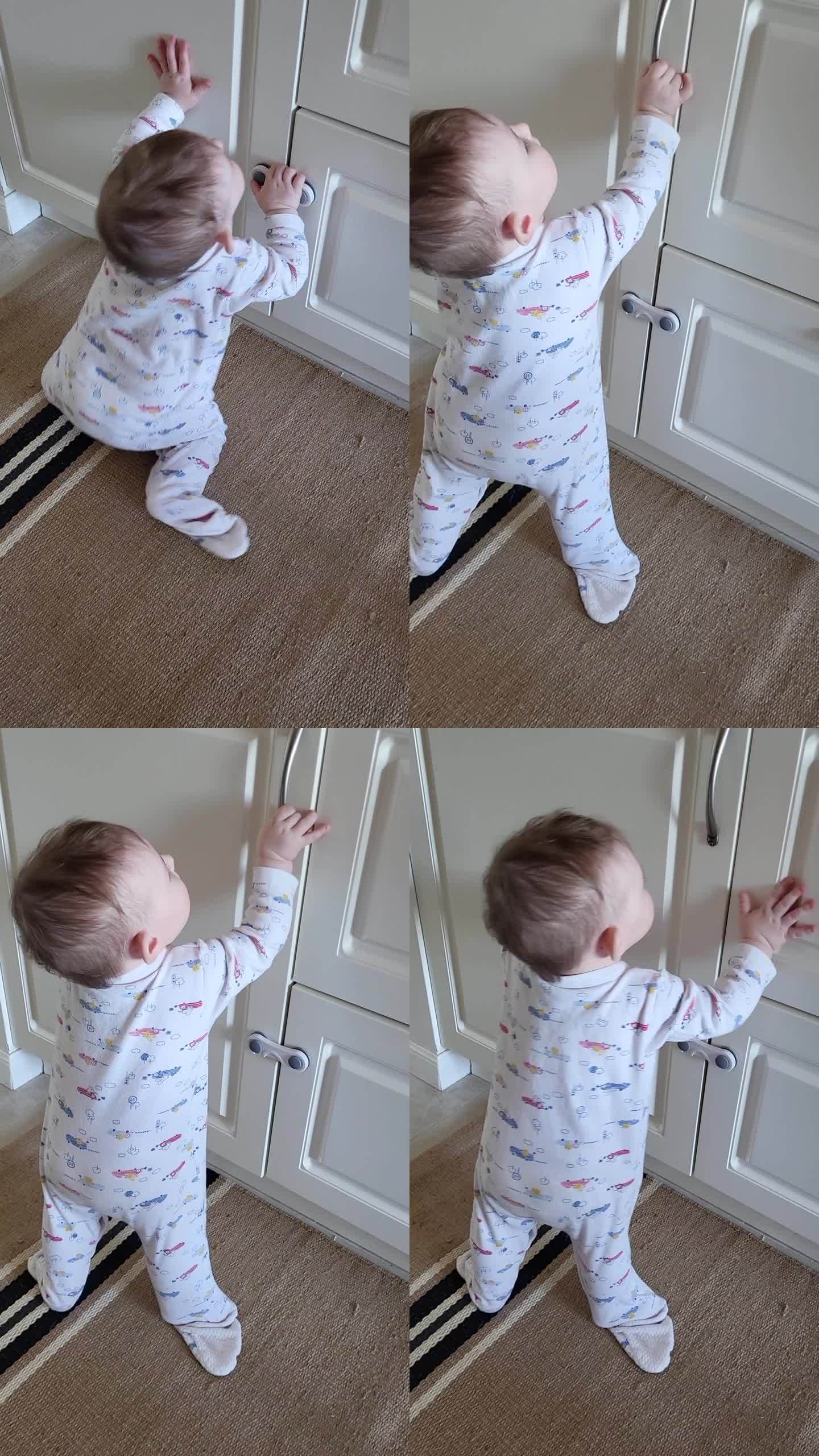 小婴儿打开了一个封闭的壁橱的门。一个好奇的孩子试图打开家具里的抽屉。8个月大的孩子