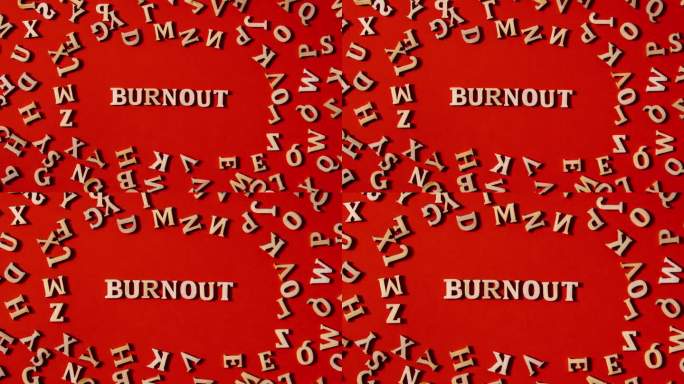 在明亮的红色背景上用木制字母制作的Word BURNOUT。励志话语引用概念。