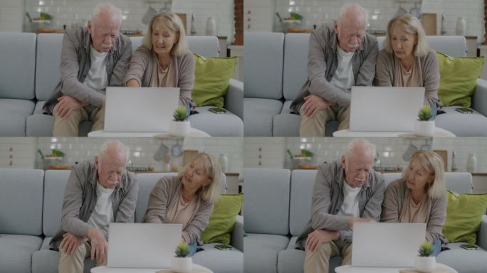 快乐的老人和女人使用笔记本电脑和聊天坐在沙发上的公寓