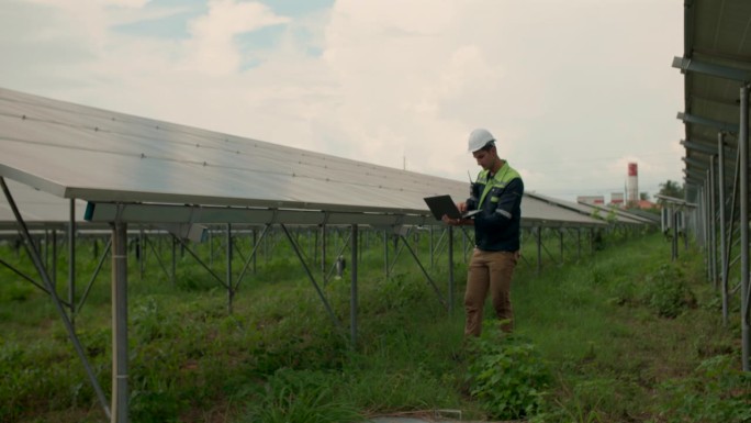 电气工程师使用笔记本电脑检查太阳能电池板的发电性能。