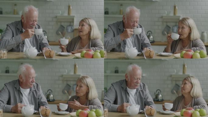 两个老人，男人和女人，在家里的厨房里喝着咖啡，碰杯聊天