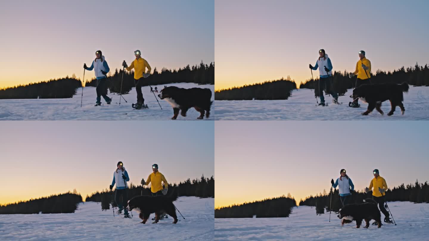 两个女人和她的狗一起在雪坡上走雪鞋